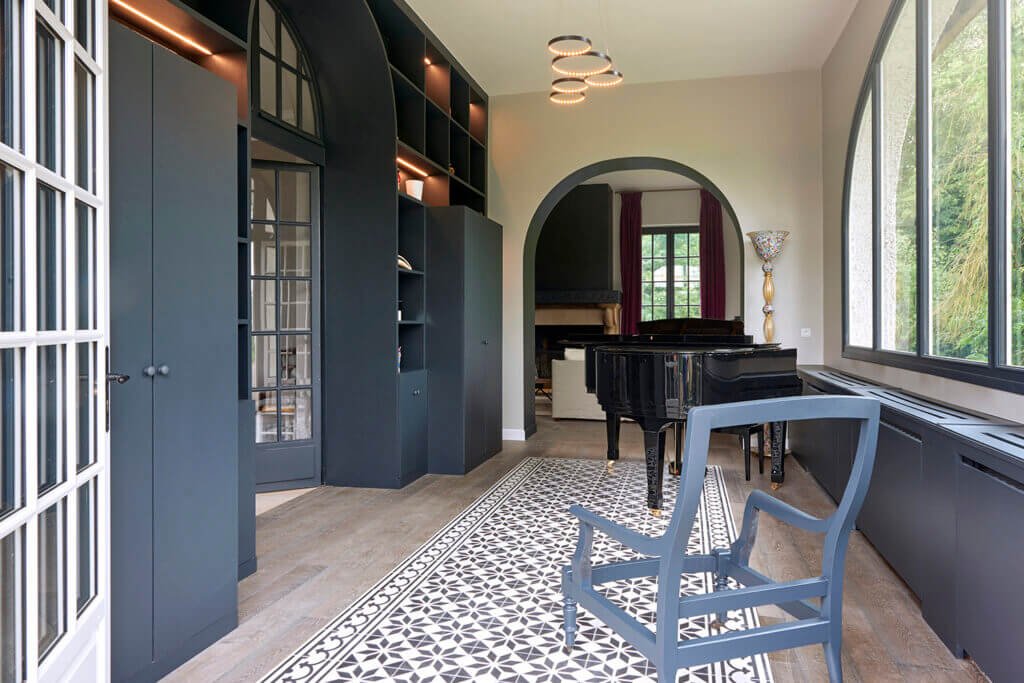 Entrance with cement tile rug framed by oak parquet flooring and bespoke bookcase