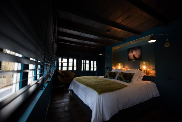 chambre bleue foncée et noire, laiton et lampes dorées, architecte d'intérieur paris