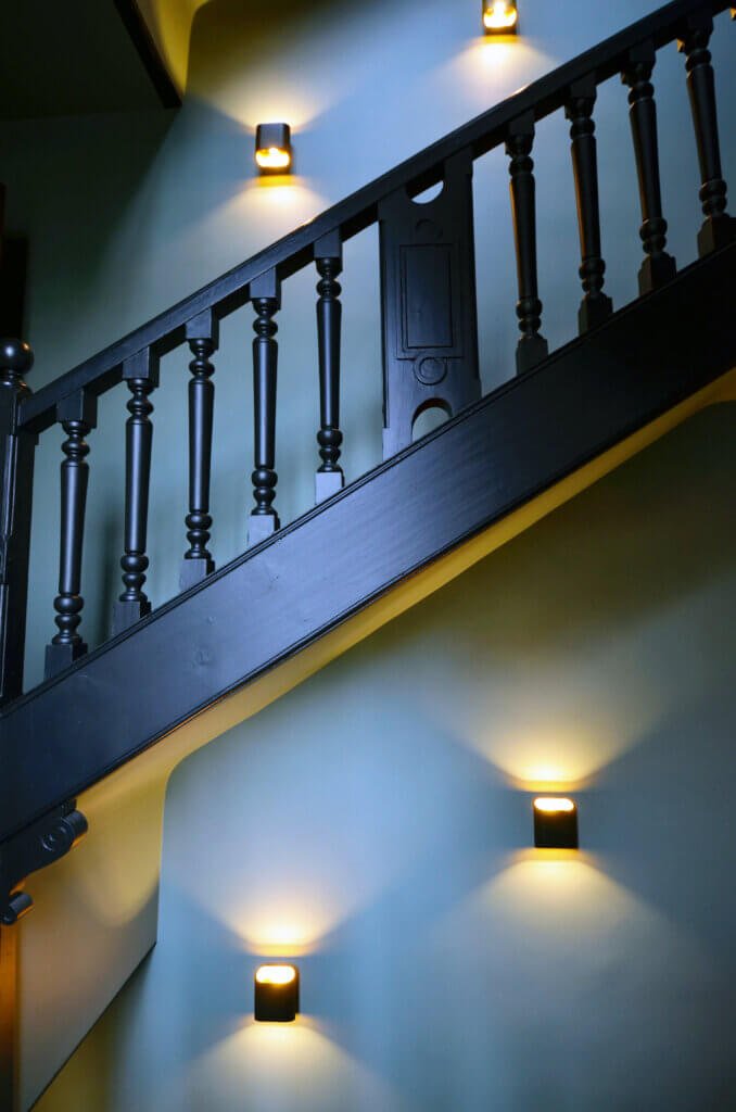 Restored wooden staircase with integrated wall lighting in a Paris private townhouse