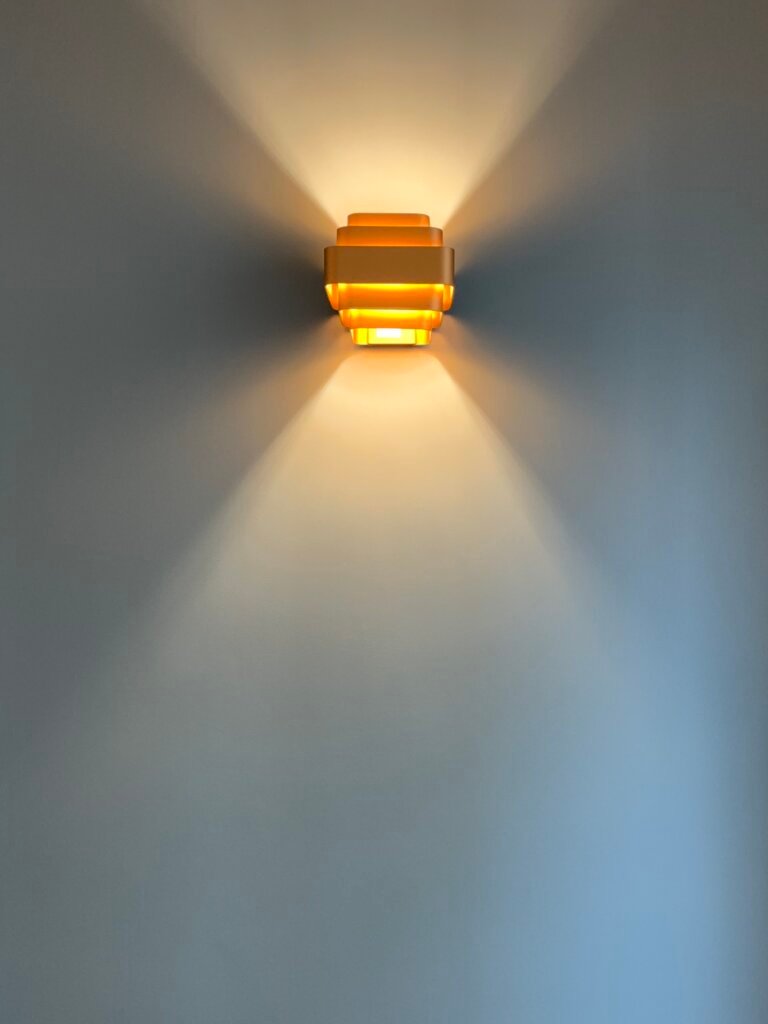 Wall-mounted sconce creating indirect ambient lighting in a Paris apartment