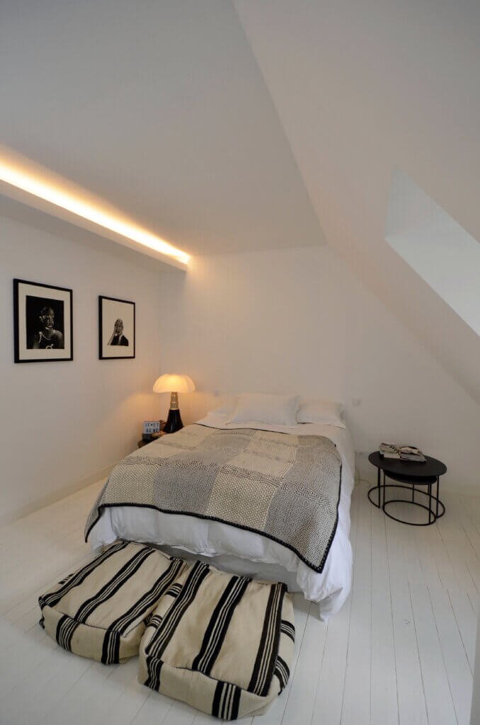Master bedroom under the roof with integrated lighting and optimized volumes in a Paris private townhouse